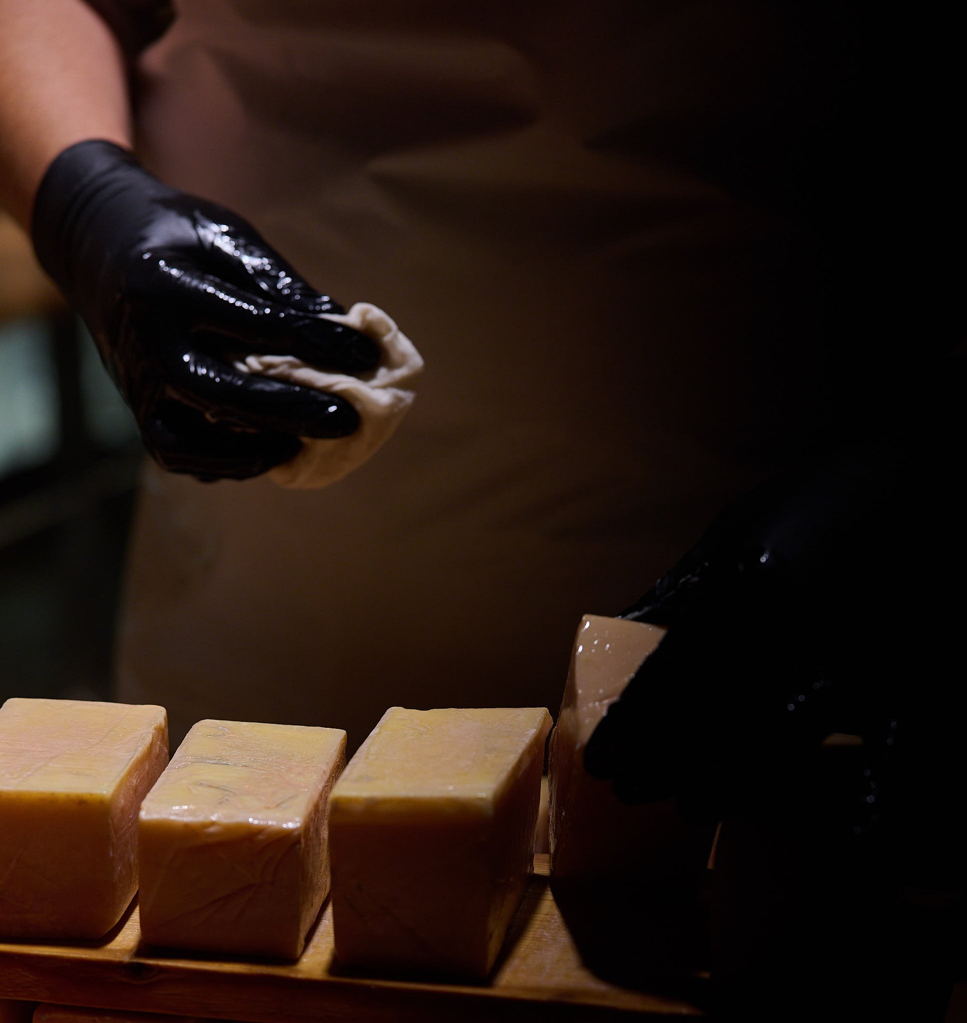 two hands with black gloves, washing cheese in Țaga cave