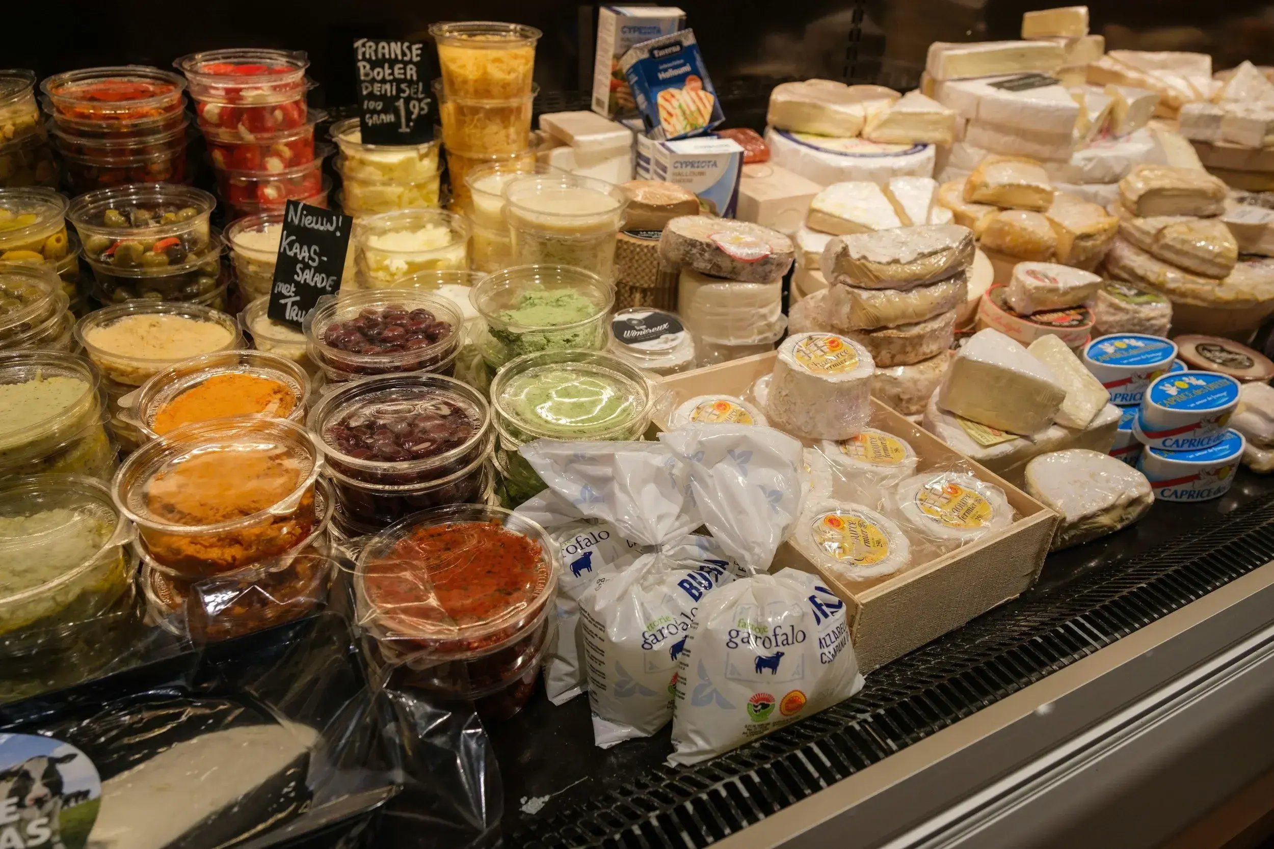 A selection of different style of cheeses ina cheese shop counter